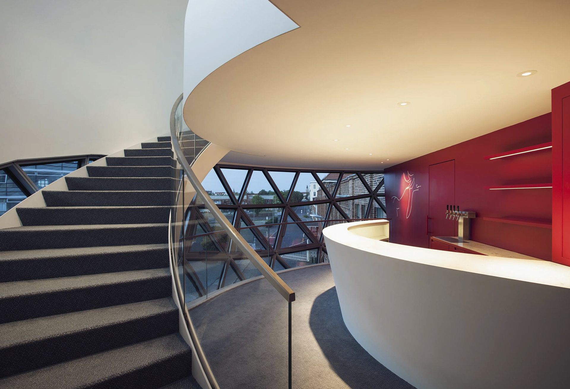 Alabaarin seinää koristaa Niemeyerin piirros. Seinän punainen väri on tyypillistä Niemeyerin arkkitehtuurissa. Portaat johtavat ylätasolle. Kuva: Margret Hoppe