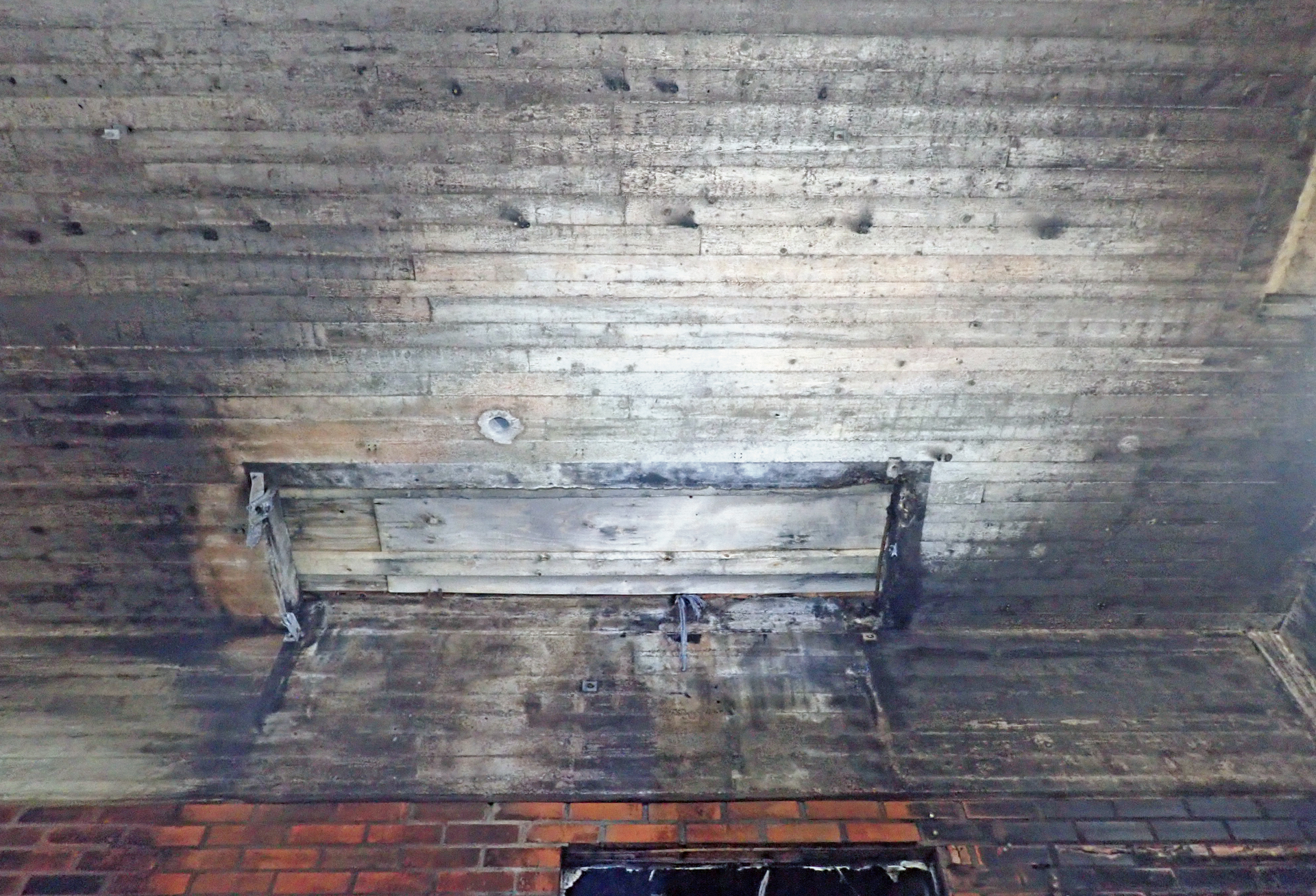 Palojälkiä betonisen välipohjan alapinnassa. Kaikki liittyvät rakenteet on jo purettu pois, mutta palon vaikutuksia arvioitaessa myös niiden merkitys lämpötiloihin ja vaikutusaikoihin täytyy huomioida. Kuva: Mika Oikari, AFRY Finland Oy